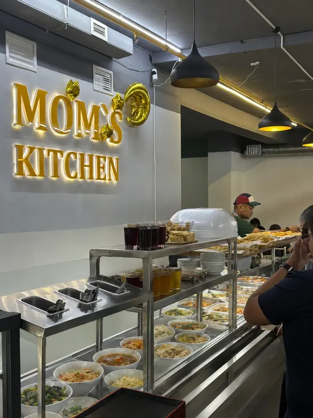 Раздача и золотая вывеска Mom’s Kitchen в зале